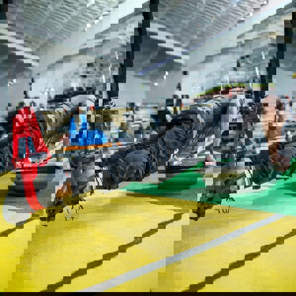 Person using suspension straps for exercise in a gym setting