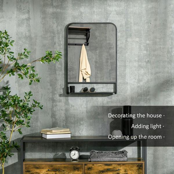 Black wall mirror with storage shelf, holding a folded towel and small accessories.