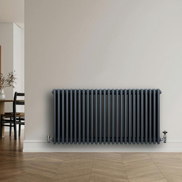 Traditional anthracite grey 4 column radiator with sleek vertical lines, mounted on a light wall, complementing modern decor