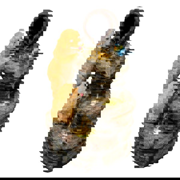 Electric water feature with two playful golden retrievers, cascading water, and a bird perched on a rustic stone fountain