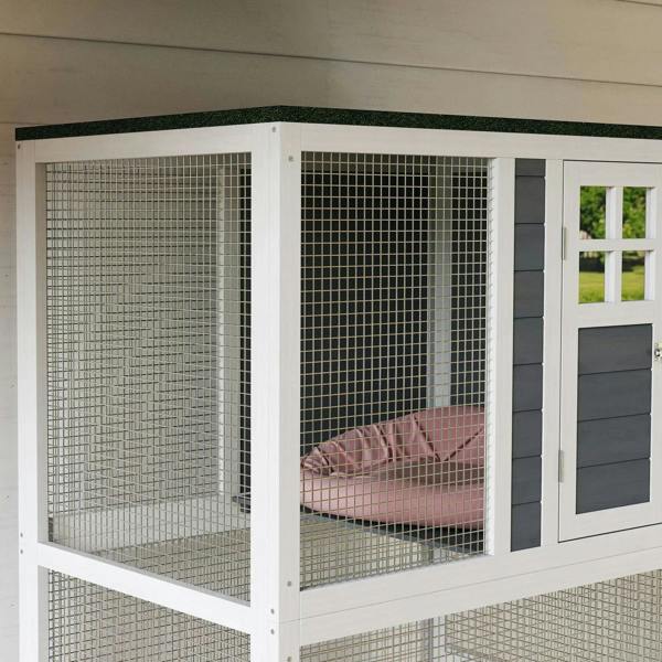 Close view of white wire mesh cat enclosure with gray panels and a pink resting hammock
