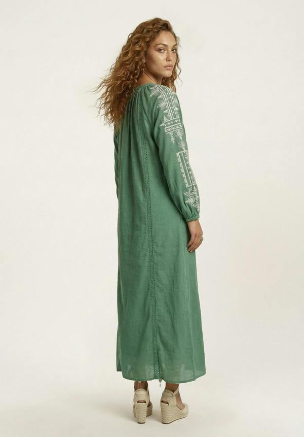 Woman wearing a green dress with text pattern on a white background