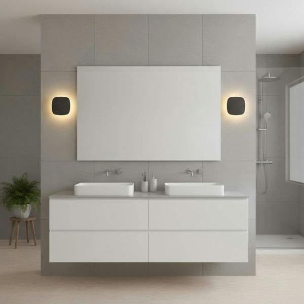 black vanity wall light shown mounted either side of a bathroom mirror in a modern bathroom