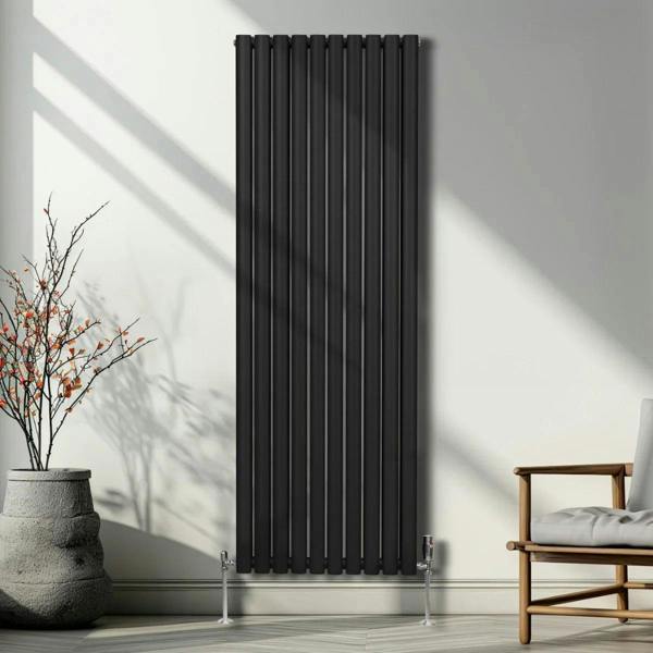 Sleek black oval column radiator measuring 1800mm x 600mm, mounted on a wall with modern decor and natural light accents