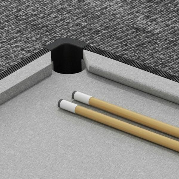 Grey pool table corner pocket with two cue sticks resting on the light playing surface.