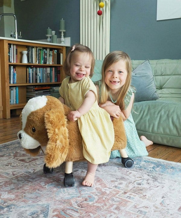 Toddler Girl and Sister playing with Peanut Pup Ride On Toy in living room Ride on toys for toddlers