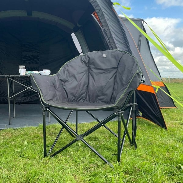 An image of the Olympus XL Camping Chair Black & Green from OLPRO outside of an awning.