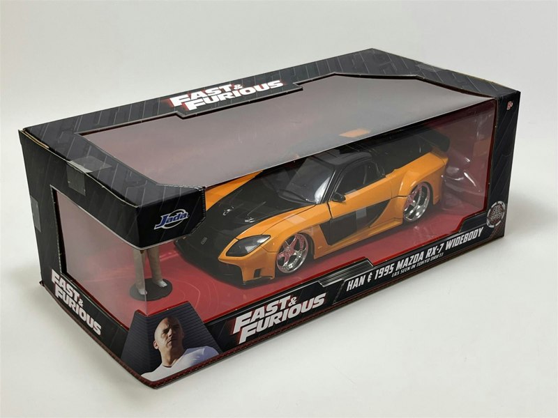 a yellow and black toy car in a box