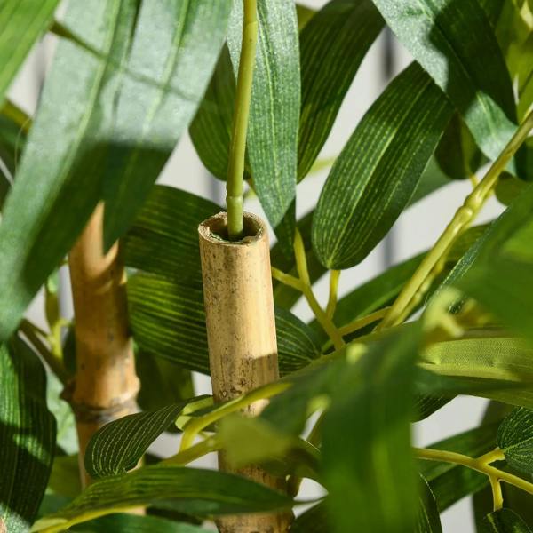 Artificial bamboo trunk stems in light tan sleeve within black planter