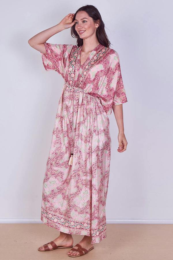 Woman wearing a pink floral dress against a white background