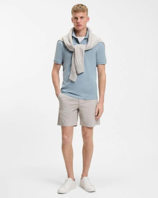 Model wearing BOSS Orange Passenger Mens Stretch-Cotton Slim-Fit Polo Shirt with Logo Patch in Light/Pastel Blue 458 - Full length