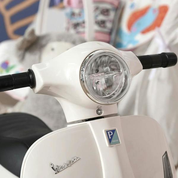 Close-up of white kids electric scooter headlight and handlebars, with handlebar grips