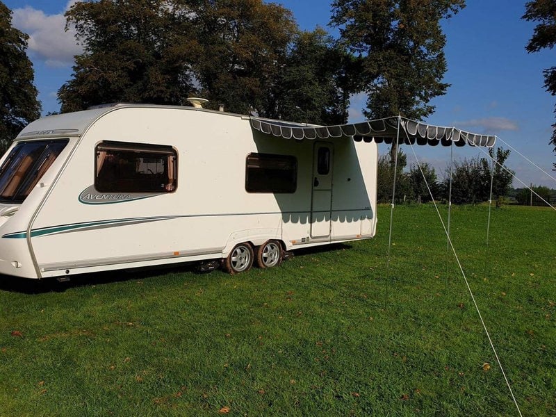 An image of the Charcoal Caravan Sun Shade Canopy from OLPRO attached to a caravan.