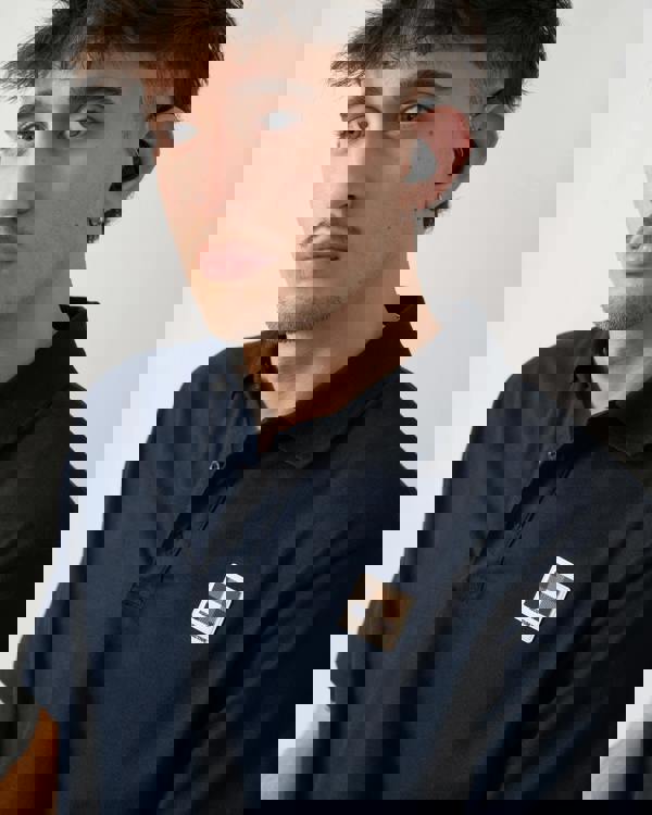 close up shot of a model wearing an Aquascutum Mens Stretch Piquet Badge Polo Shirt in Navy 11