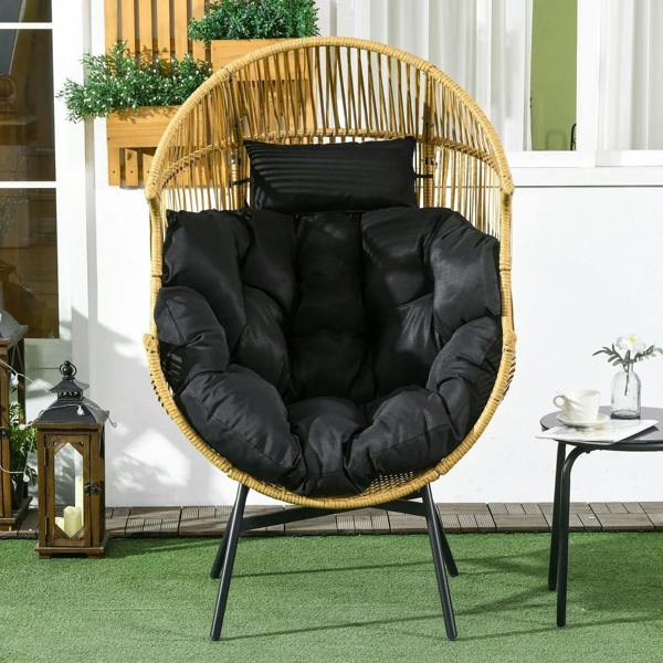 Woven rattan egg chair with thick black cushion, curved back, and armrests