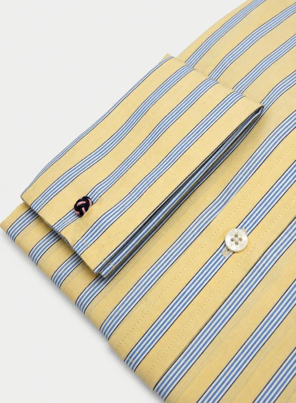 A folded long-sleeve dress shirt with a yellow base and thin blue and white vertical stripes, featuring a buttoned cuff and a white button.