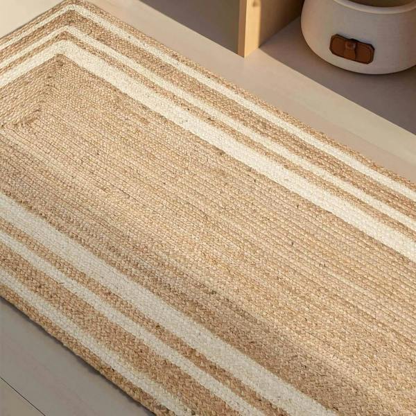 Beige and white striped rug on a light wooden floor