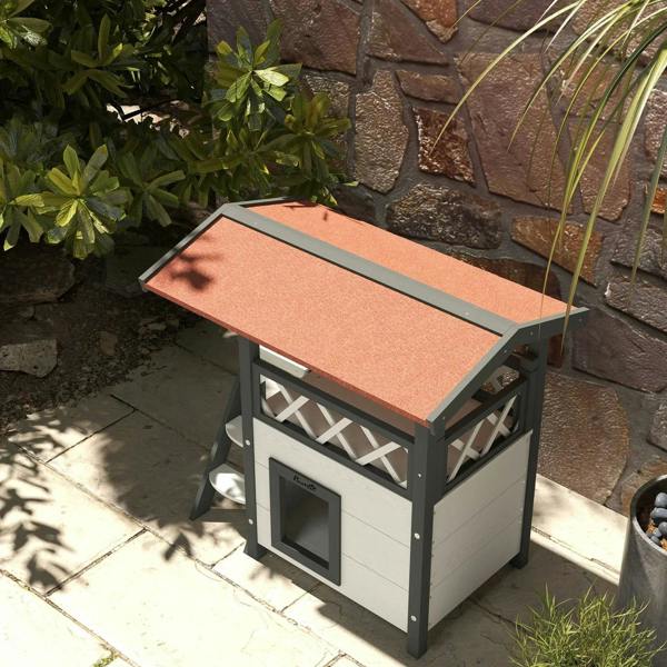 White outdoor cat house with roof panel and front cat door on patio