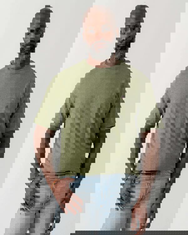 model wearing a GANT Mens Regular Fit Short Sleeve Shield Logo T-Shirt in Dark Cactus Melange