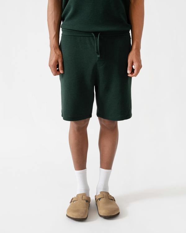 Man wearing BOSS Orange Waffle Mens Cotton Blend Waffle Structure Pyjama Shorts with Embroidered Logo - Dark Green 308