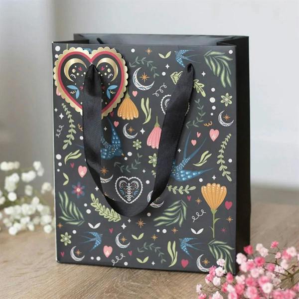 Medium black gift bag with Midnight Bloom floral, moon and heart print; black rope handles