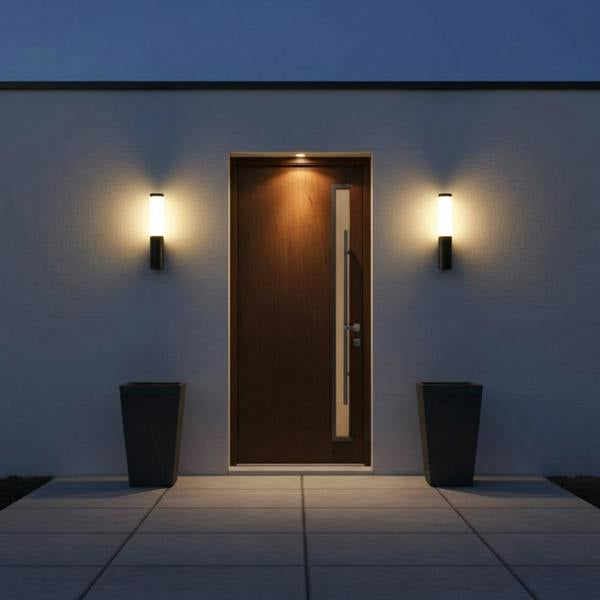 black outdoor wall lantern light mounted either side of a wooden front door 