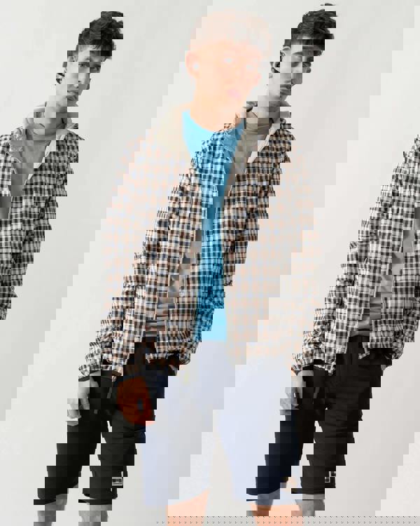 mid shot of a model wearing an Aquascutum Mens RLG Badge Reversible Sailor Jacket in Salvia 34 showing reversed check pattern