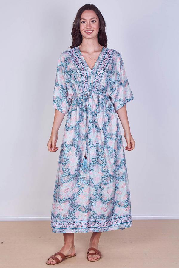 Woman wearing a floral dress against a plain background
