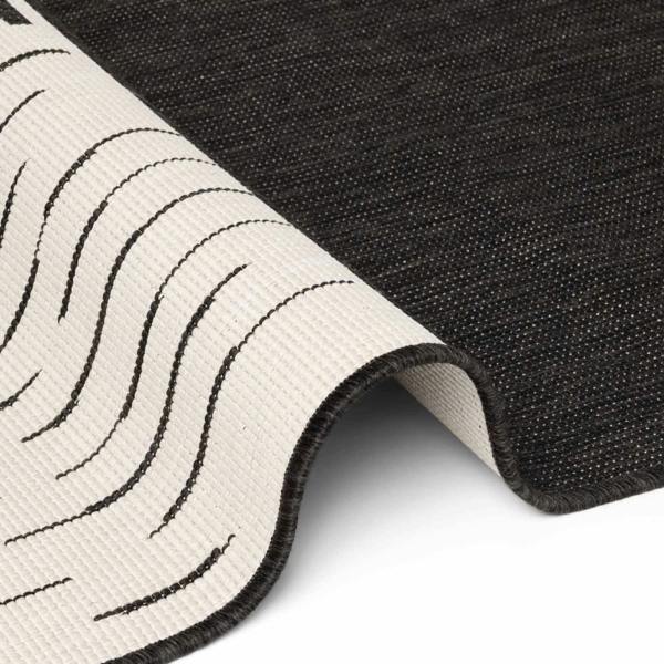 Close-up of a black and white textured rug corner.