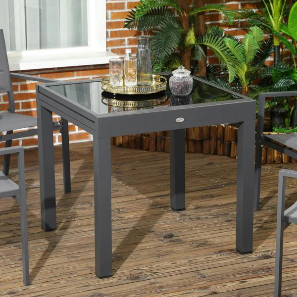 Extending outdoor dining table with dark tempered glass tabletop and aluminium frame