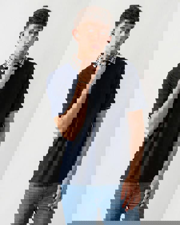 Studio shot of a model wearing an Aquascutum Mens Club Check Collar Polo Shirt in Navy 11