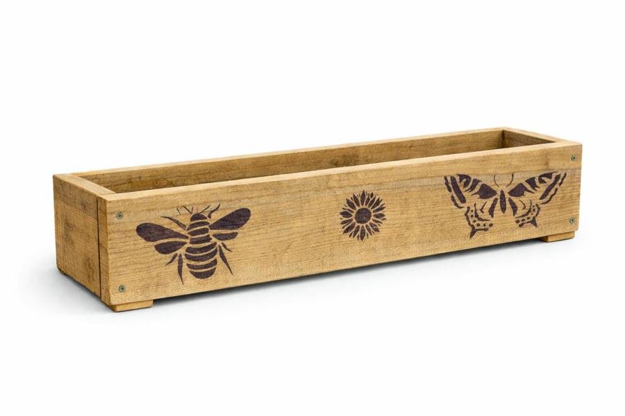 Decorated rough sawn wooden garden trough 80cm long on a white background