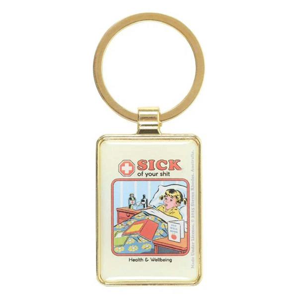Gold keyring with square charm showing “SICK of your shit” comic art and “Health & Wellbeing”