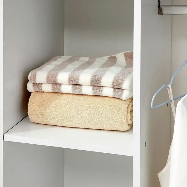 Close-up of interior storage shelves with folded towels in a white wardrobe