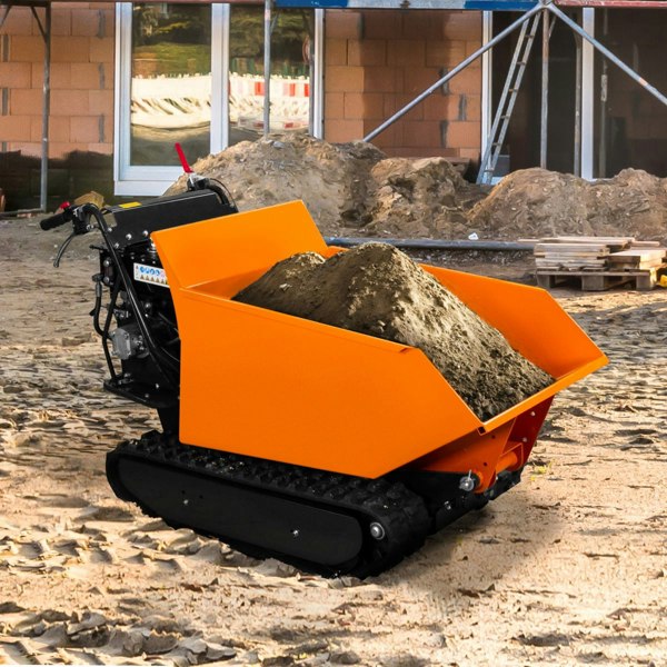 Tracked mini dumper petrol tipper with a bright orange steel bucket filled with dirt, set on a construction site with gravel and machinery in the background