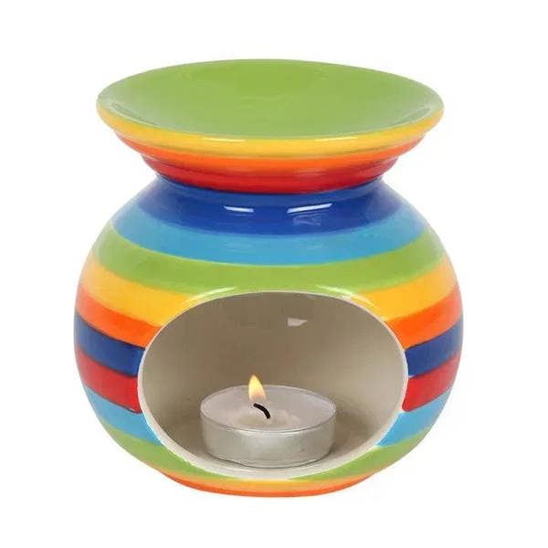 Rainbow striped oil burner with lit tealight candle inside, colorful glossy ceramic jug