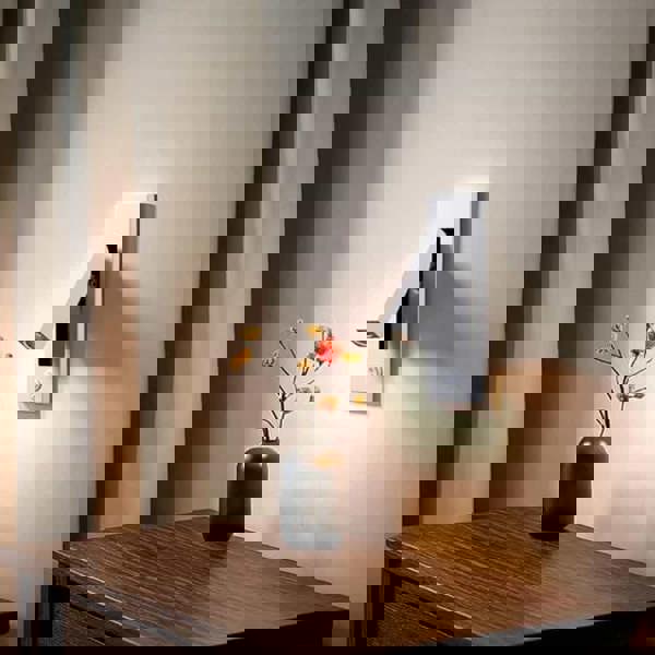 white recessed bedroom reading lamp mounted over a bedside table in a bedroom