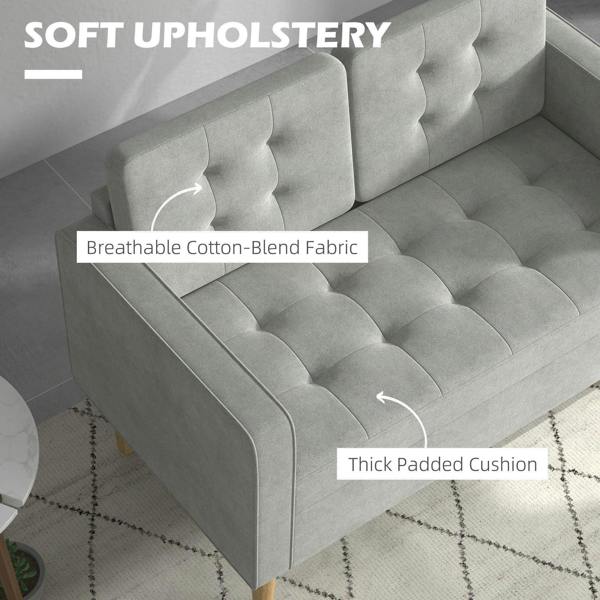 Light grey sofa upholstery with tufted panels and thick padded seat cushion