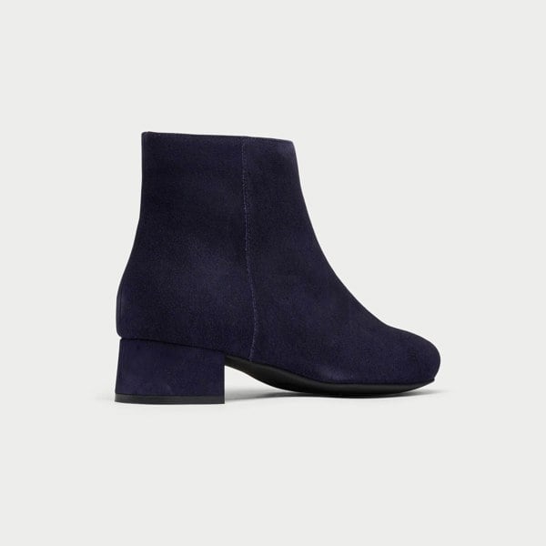 Navy blue ankle boot on a light gray background