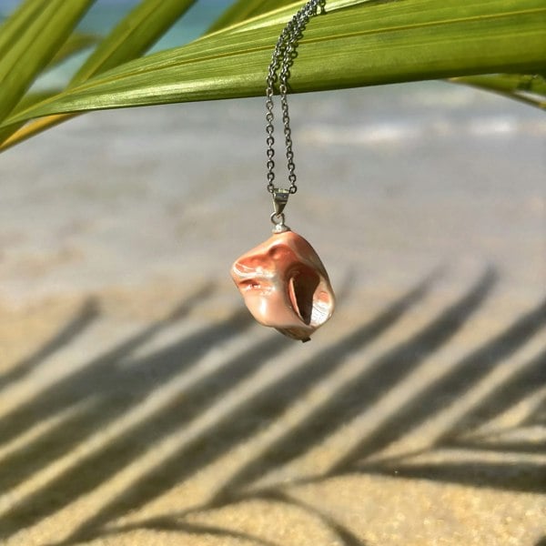 Natural shell pendant charm by LENAE featuring salmon toned electroplated shells. Photographed on a castaway beach.