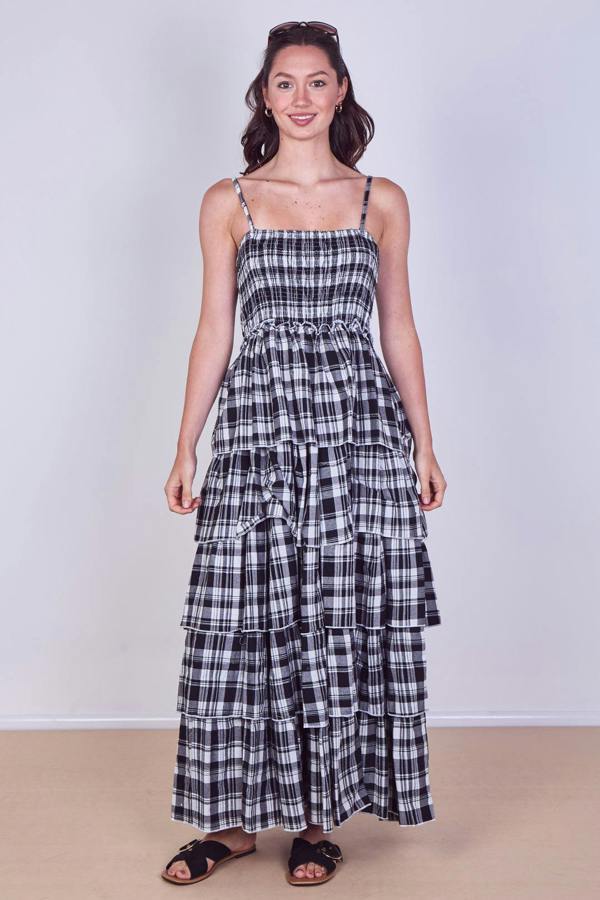 Woman wearing a black and white checkered dress against a plain background