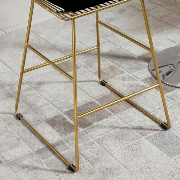 Gold metal bar stool legs with non-slip foot pads on textured floor