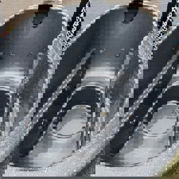 A wood-fired ofuro style hot tub with integrated heater, featuring a fibreglass liner and surrounded by wooden steps, a chimney guard, and a drinks shelf.