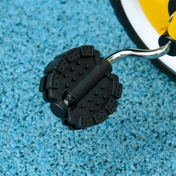 Black bell mechanism with textured mounting on a yellow tricycle handle
