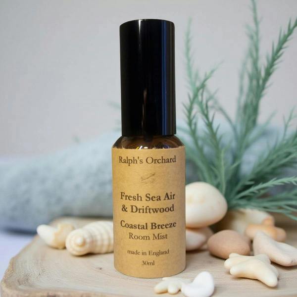Ralph's Orchard Fresh Sea Air & Driftwood Coastal Breeze Room Mist bottle with natural elements on a wooden board.