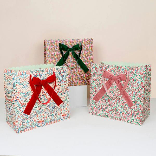 Set of three large Liberty print Christmas gift bags with velvet handles and ribbon bows.