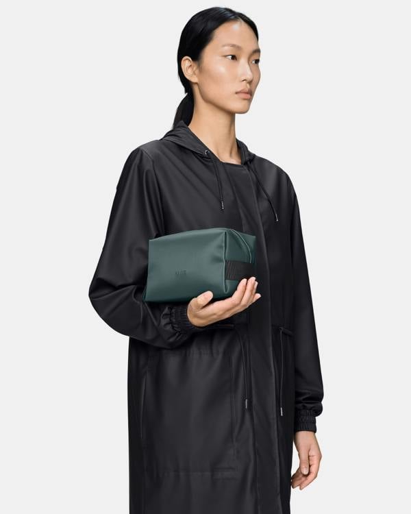 model holding a Rains Wash Bag Small in 175 Mystique
