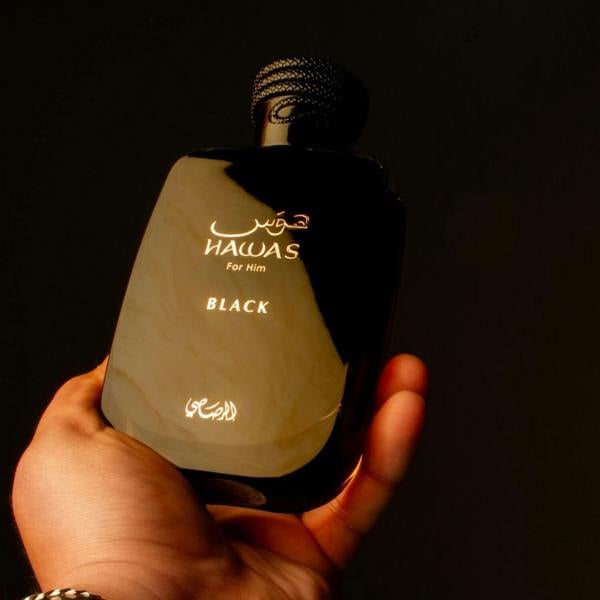 Rasasi Hawas Black Eau de Parfum 100ml bottle in hand on dark background