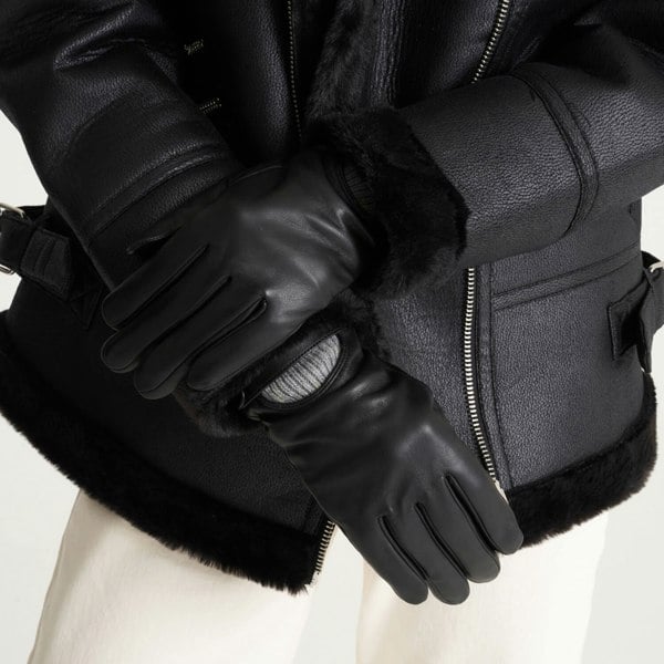 Image shows a models hands. The model wears a pair of leather gloves that have a knitted cuff detail.