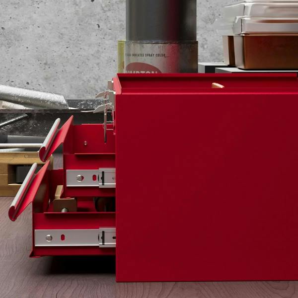 Red metal tool box open interior with compartments and two slide-out drawers
